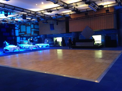 Salle de danse avec un sol en bois et un éclairage bleu. Ambiance moderne et spacieuse.